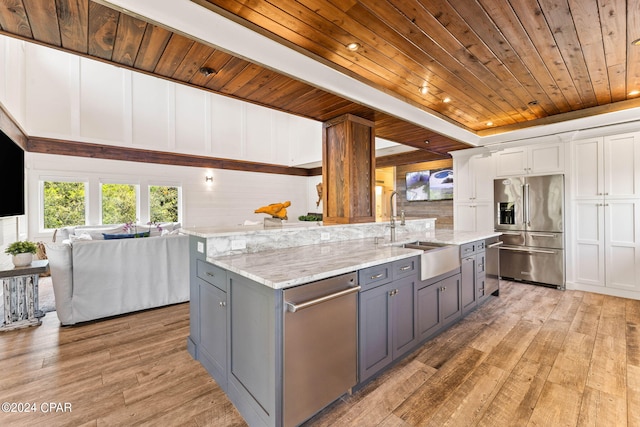 kitchen featuring stainless steel appliances, light wood-type flooring, sink, and white cabinetry