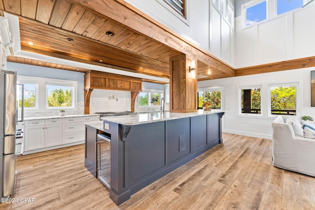 kitchen featuring light stone counters, white cabinets, light hardwood / wood-style floors, and a kitchen island