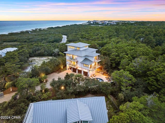 aerial view at dusk featuring a water view