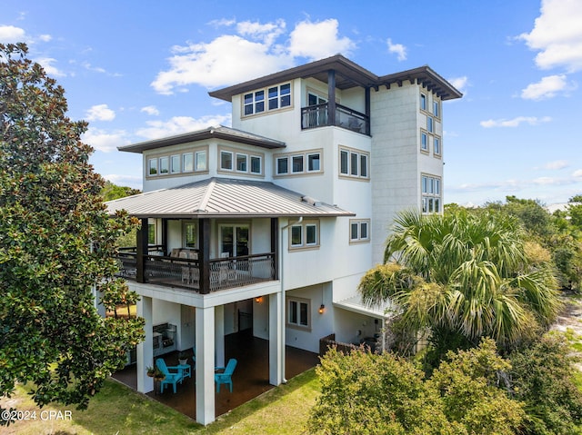 rear view of house featuring a balcony and a patio area