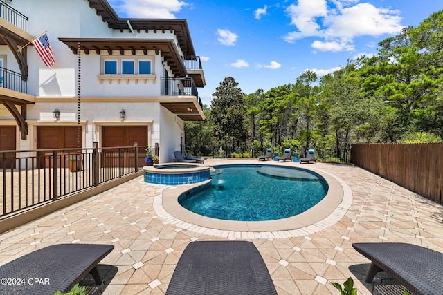 view of pool featuring a patio and an in ground hot tub