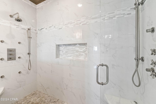 bathroom featuring a shower with door