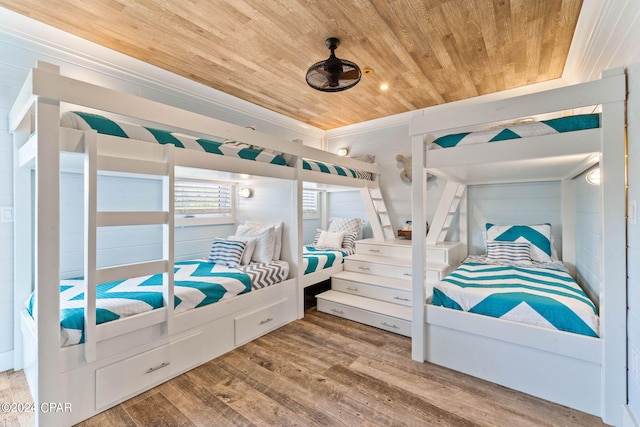 bedroom with wood ceiling, wooden walls, and hardwood / wood-style floors