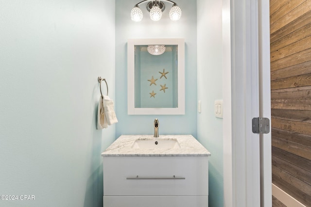 bathroom featuring vanity and wood walls