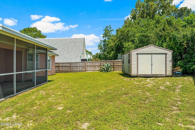 view of yard with a sunroom and a storage shed