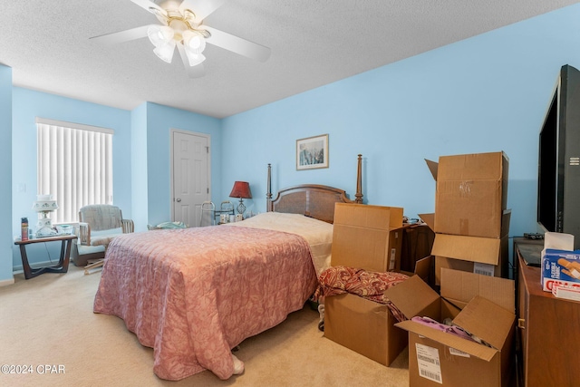 bedroom featuring ceiling fan, a textured ceiling, and light carpet