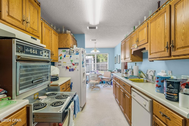 kitchen featuring sink, white appliances, a textured ceiling, decorative light fixtures, and light colored carpet