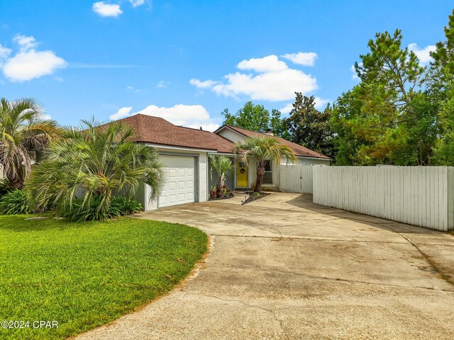 view of front of house featuring a garage and a front lawn