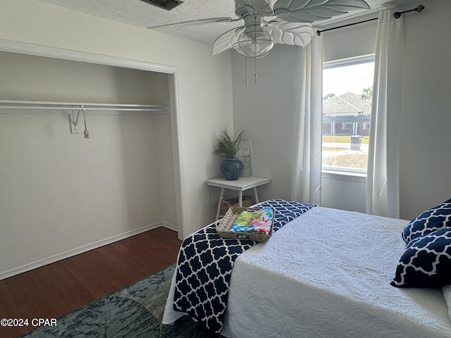 bedroom featuring hardwood / wood-style floors, a textured ceiling, ceiling fan, and a closet