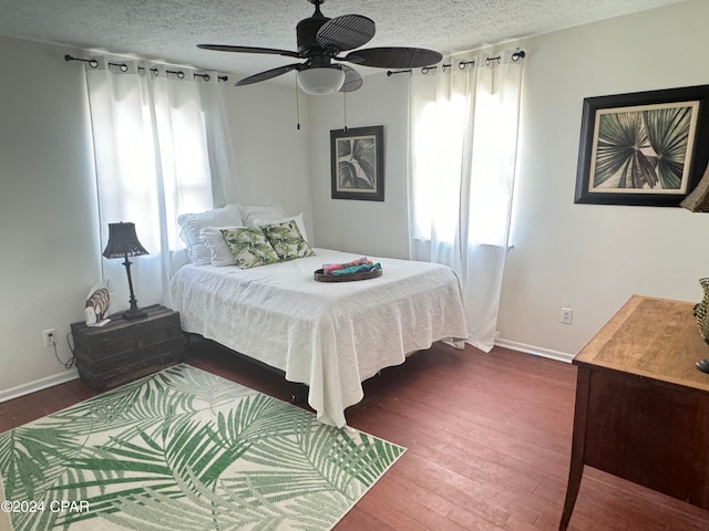 bedroom featuring multiple windows, a textured ceiling, ceiling fan, and hardwood / wood-style floors