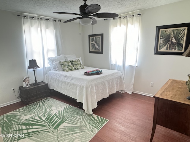 bedroom with ceiling fan, dark hardwood / wood-style floors, and a textured ceiling