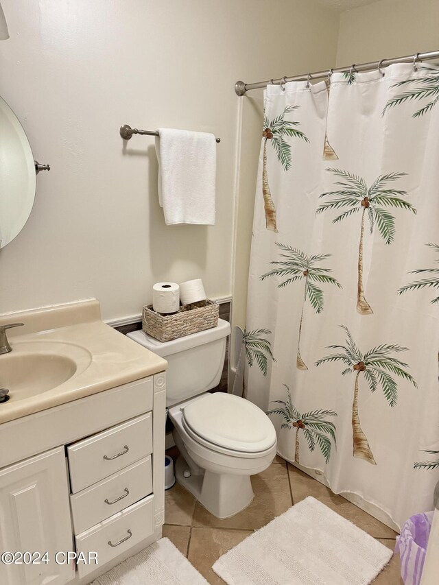 bathroom featuring tile patterned flooring, toilet, and vanity