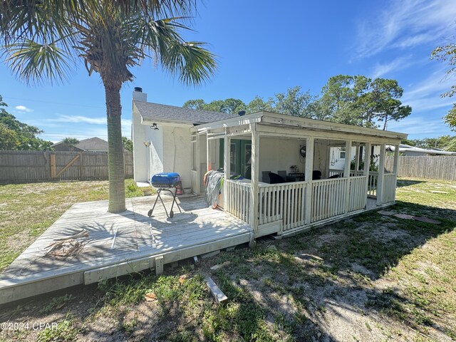 back of house featuring a wooden deck and a yard