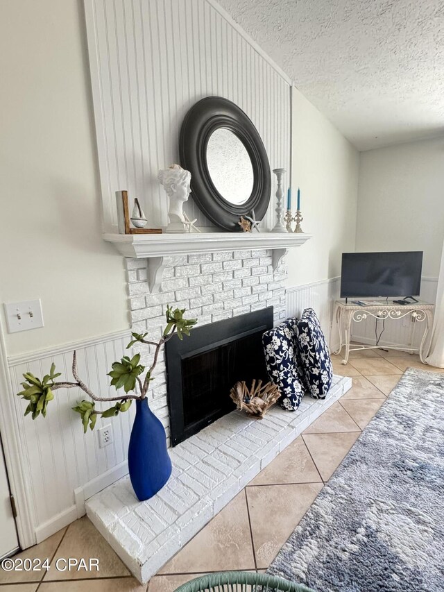 tiled living room featuring a fireplace and a textured ceiling