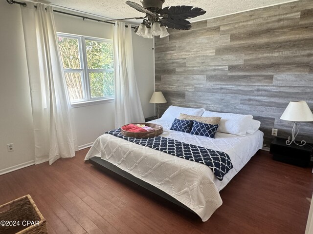 bedroom featuring wood-type flooring, a textured ceiling, and ceiling fan