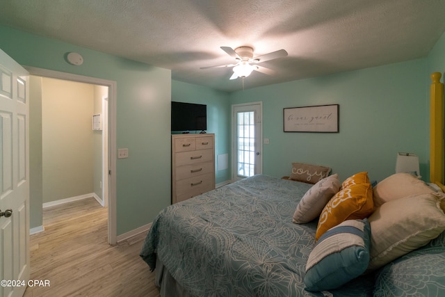 bedroom featuring ceiling fan, a textured ceiling, and light hardwood / wood-style flooring