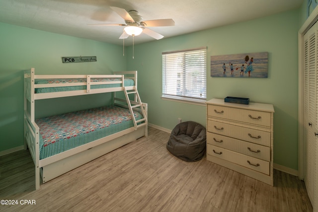 bedroom with a closet, light wood-type flooring, and ceiling fan