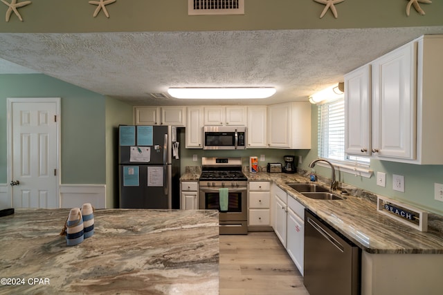 kitchen featuring white cabinets, appliances with stainless steel finishes, sink, and a textured ceiling