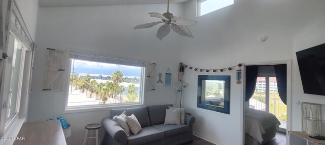 living room featuring a healthy amount of sunlight, a towering ceiling, and ceiling fan