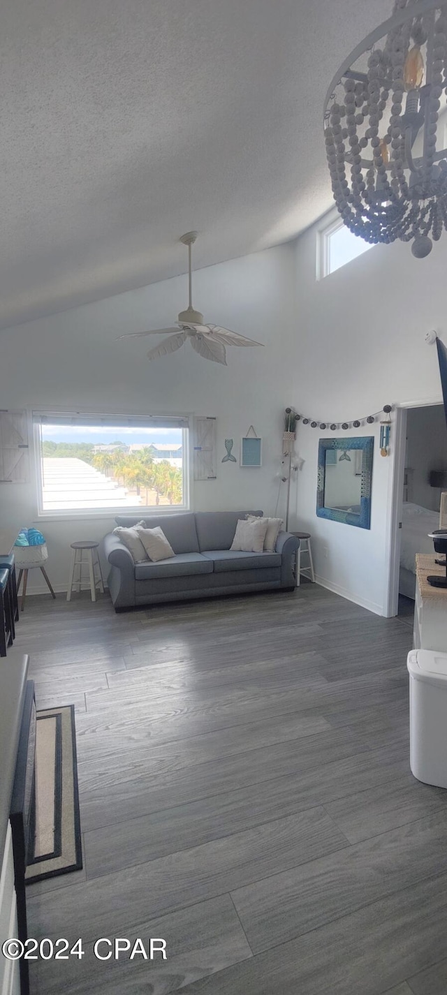 living room with lofted ceiling, a textured ceiling, hardwood / wood-style floors, and ceiling fan