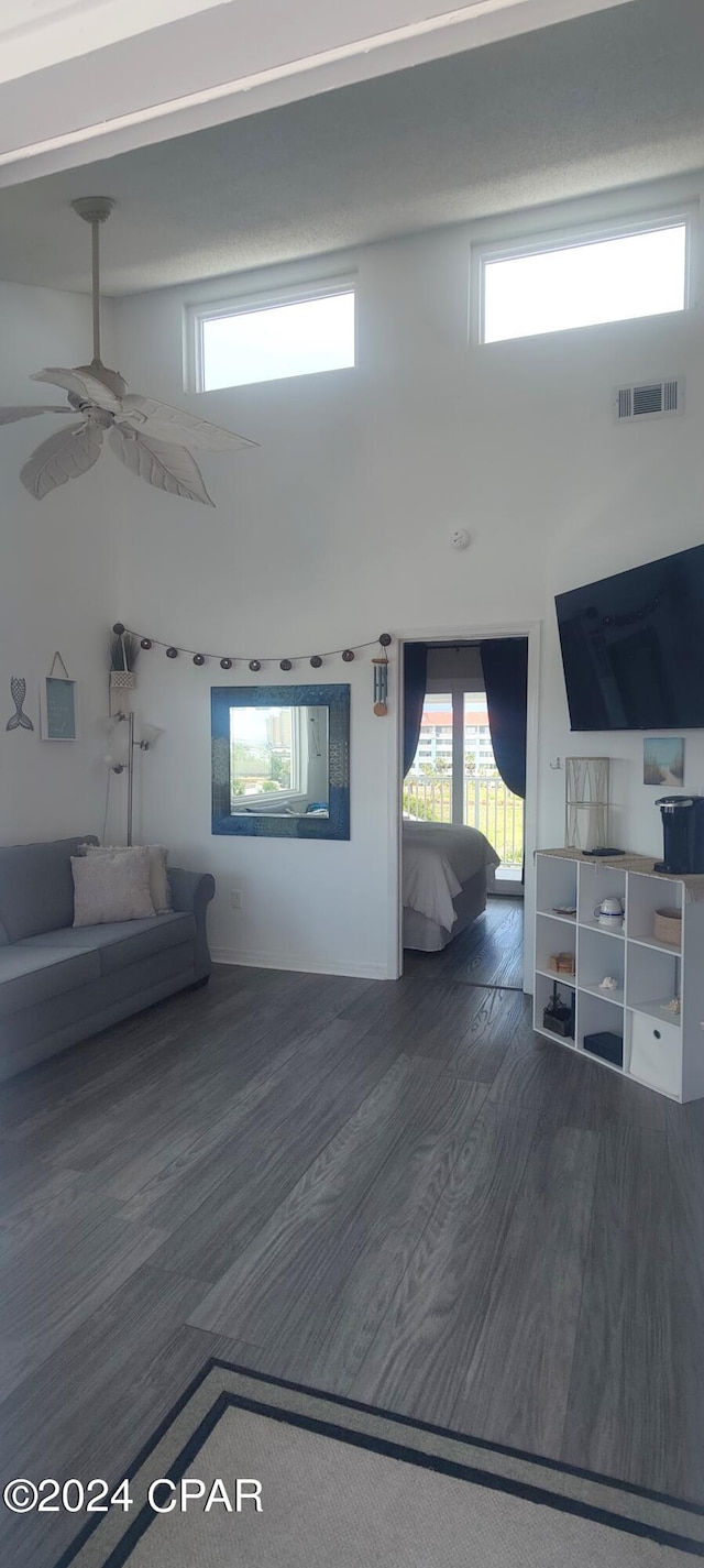 unfurnished living room featuring ceiling fan and dark hardwood / wood-style floors