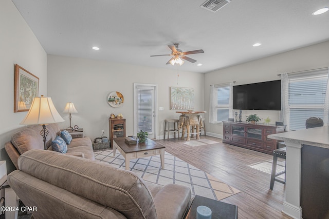 living room with light hardwood / wood-style flooring and ceiling fan