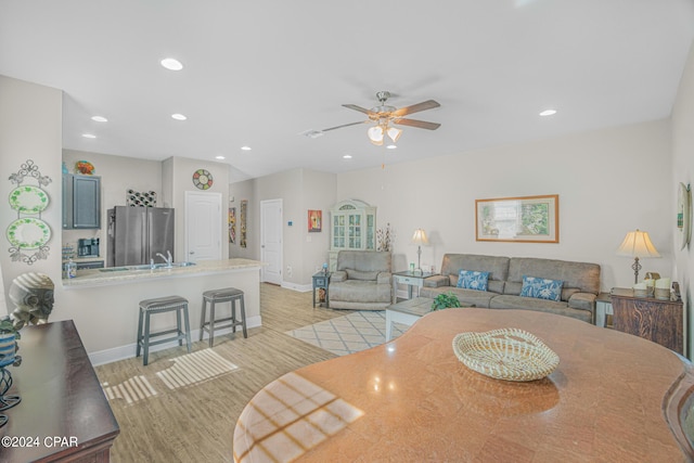 dining room with sink, ceiling fan, and light hardwood / wood-style flooring