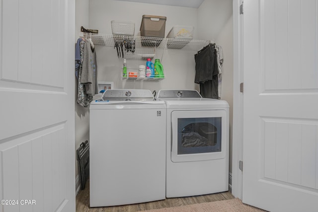 laundry area with independent washer and dryer and light wood-type flooring