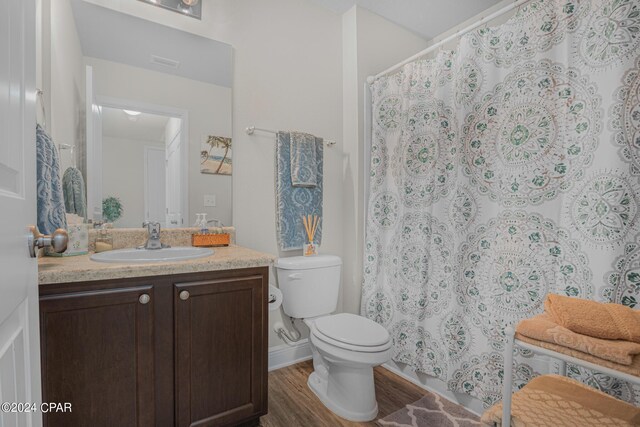 bathroom featuring vanity, wood-type flooring, and toilet