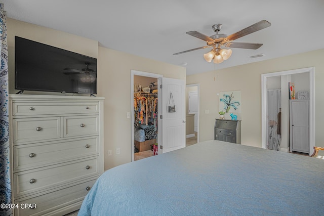 bedroom with ceiling fan, ensuite bathroom, a spacious closet, and a closet