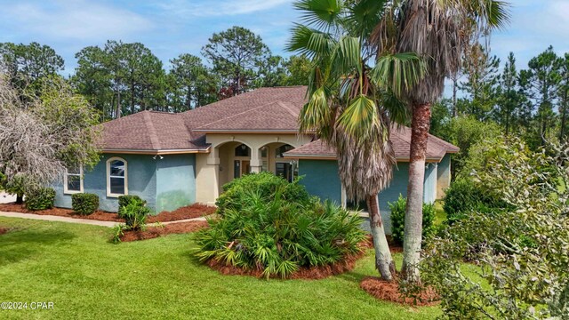 mediterranean / spanish-style house featuring a front lawn