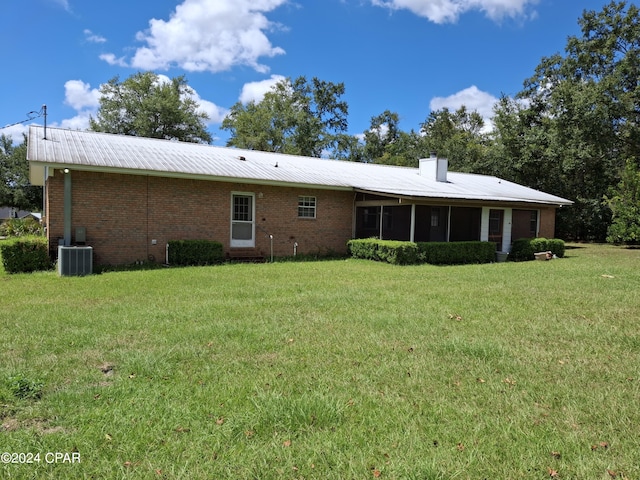 rear view of property featuring a yard and central air condition unit