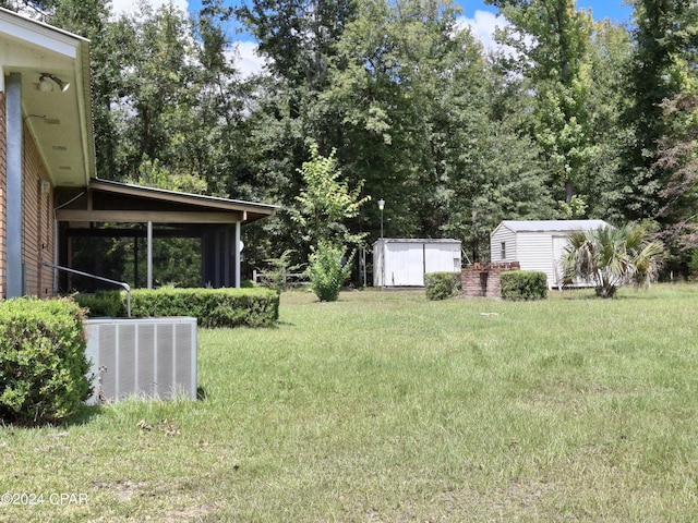 view of yard featuring central AC and a storage unit