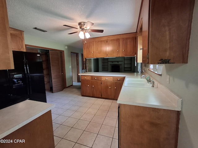 kitchen featuring sink, light tile patterned floors, ceiling fan, a textured ceiling, and black fridge with ice dispenser