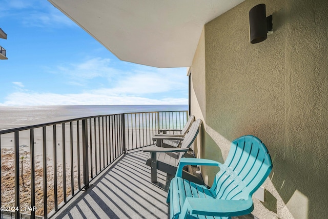 balcony featuring a water view and a beach view