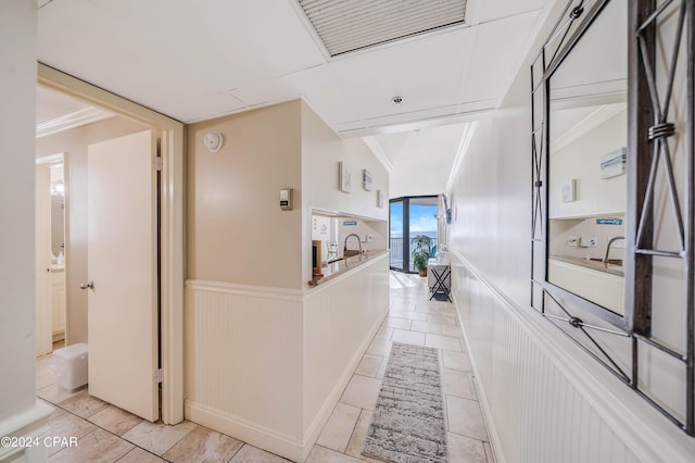 hall featuring ornamental molding and light tile patterned floors