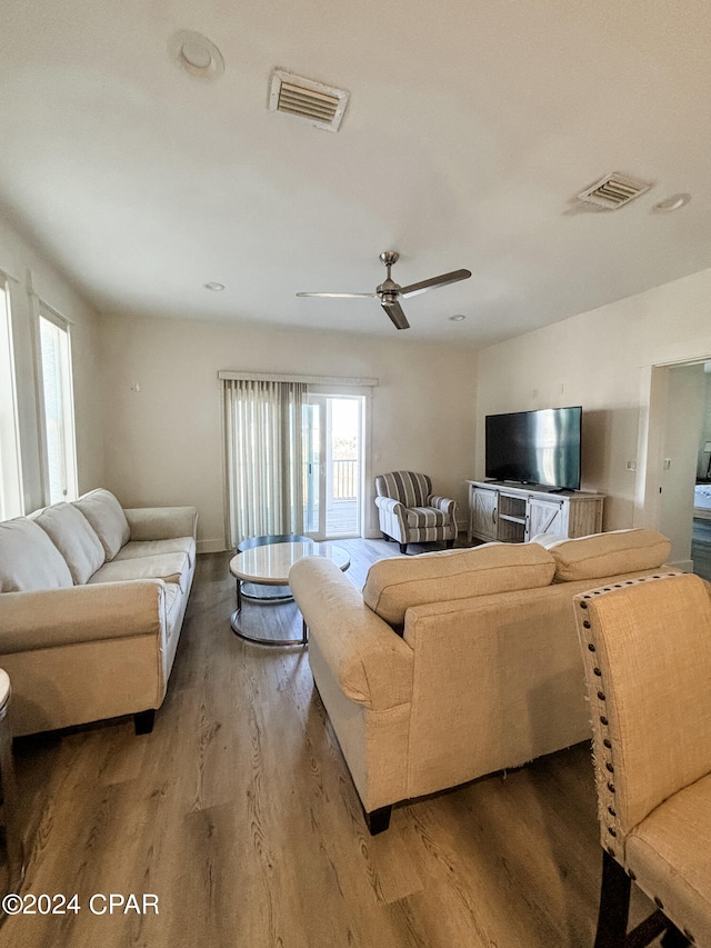 living room featuring wood-type flooring and ceiling fan