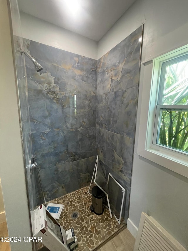 bathroom featuring tiled shower and hardwood / wood-style floors