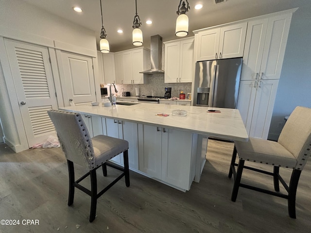 kitchen with wall chimney range hood, sink, dark hardwood / wood-style floors, and stainless steel appliances