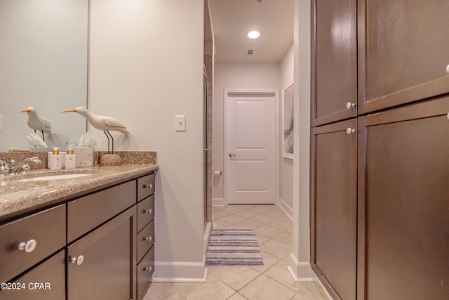 bathroom featuring walk in shower, vanity, and tile patterned flooring