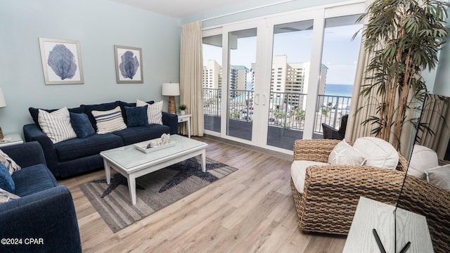 living room featuring a water view and light hardwood / wood-style flooring