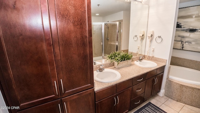 bathroom featuring shower with separate bathtub, vanity, and tile patterned floors