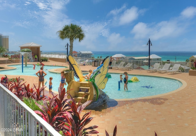 view of pool featuring a patio area and a water view