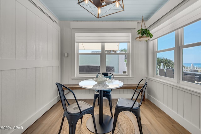 dining area featuring light hardwood / wood-style flooring and a water view