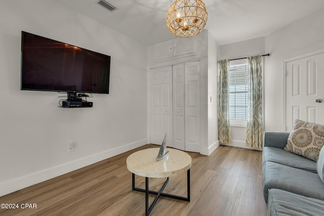 living room with light wood-type flooring and a notable chandelier