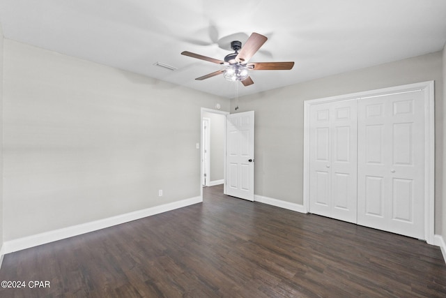 unfurnished bedroom with ceiling fan, dark hardwood / wood-style flooring, and a closet