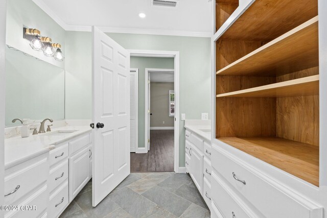 bathroom with crown molding, hardwood / wood-style floors, and vanity