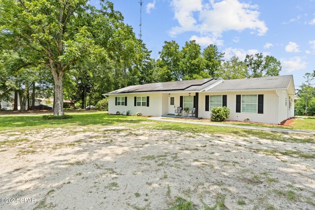 single story home with covered porch and solar panels