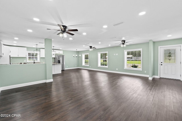 unfurnished living room featuring dark hardwood / wood-style flooring and an inviting chandelier