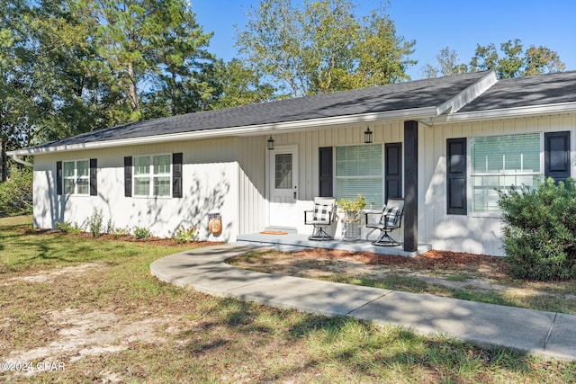 ranch-style home featuring a porch and a front yard